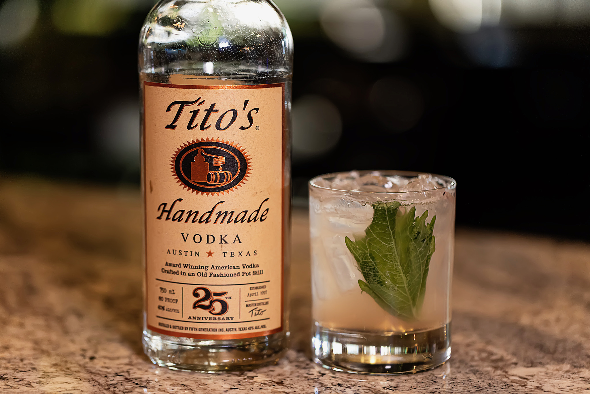 Bottle of Tito's Handmade Vodka displayed beside a vodka cocktail with ice and fresh mint in a rocks glass at Old Florida Fish House.