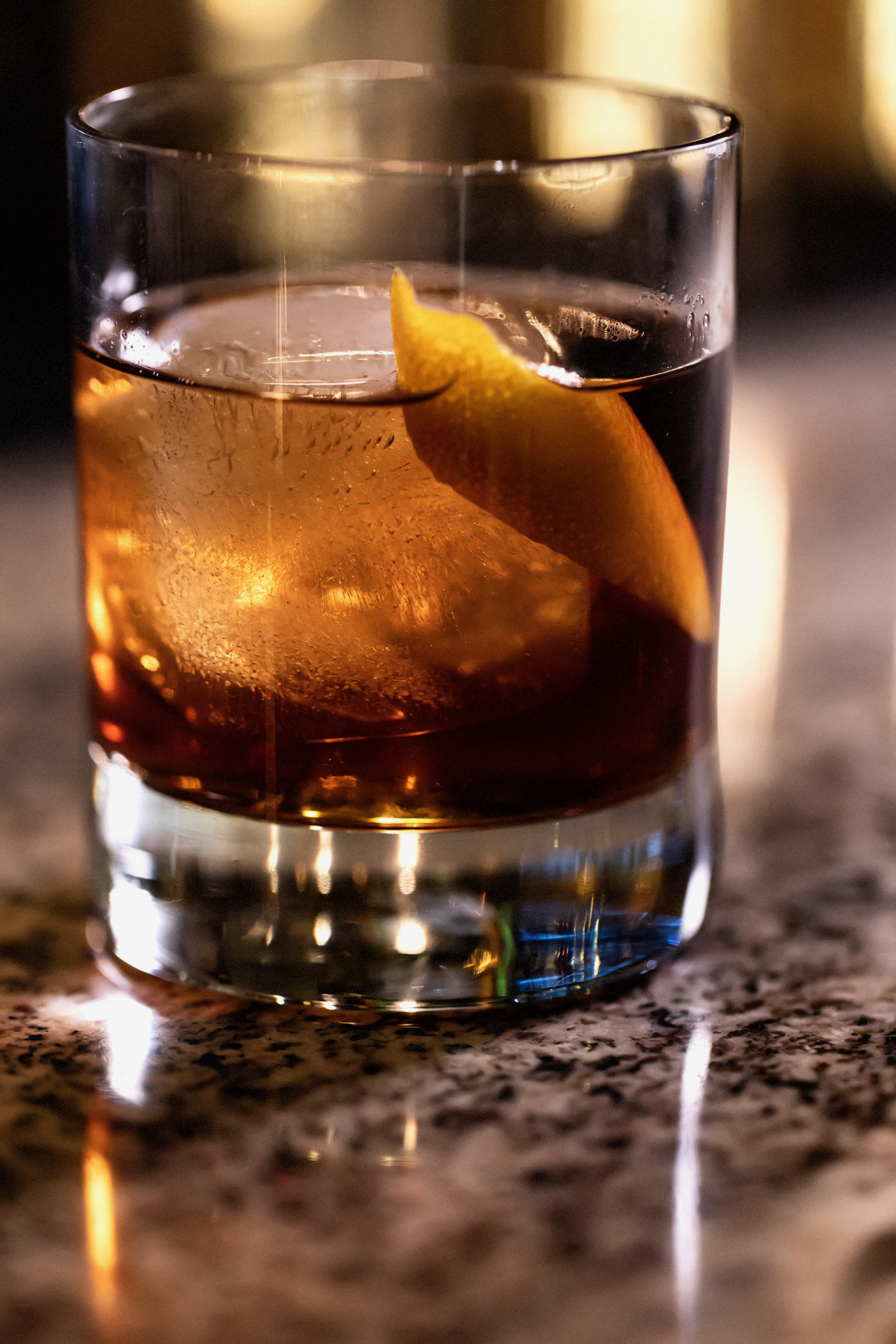 Old Fashioned cocktail with a large clear ice cube and orange peel garnish served in a rocks glass on the bar at Old Florida Fish House.