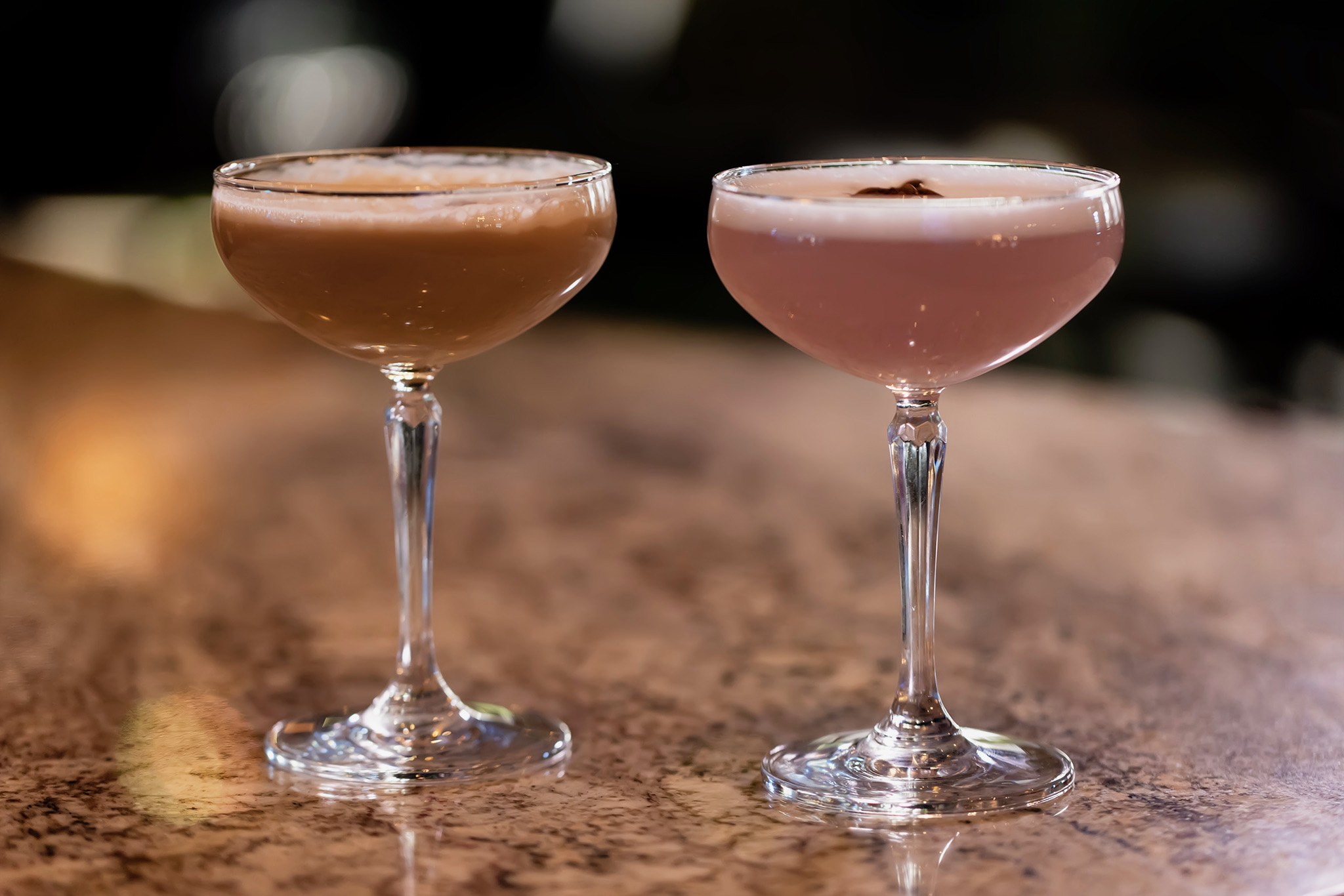 Two handcrafted signature cocktails served in coupe glasses on the bar at Old Florida Fish House.