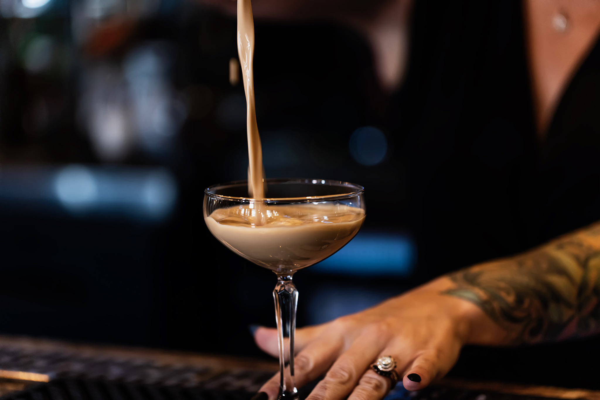 Creamy espresso martini being poured into a coupe glass by the bartender at Old Florida Fish House.