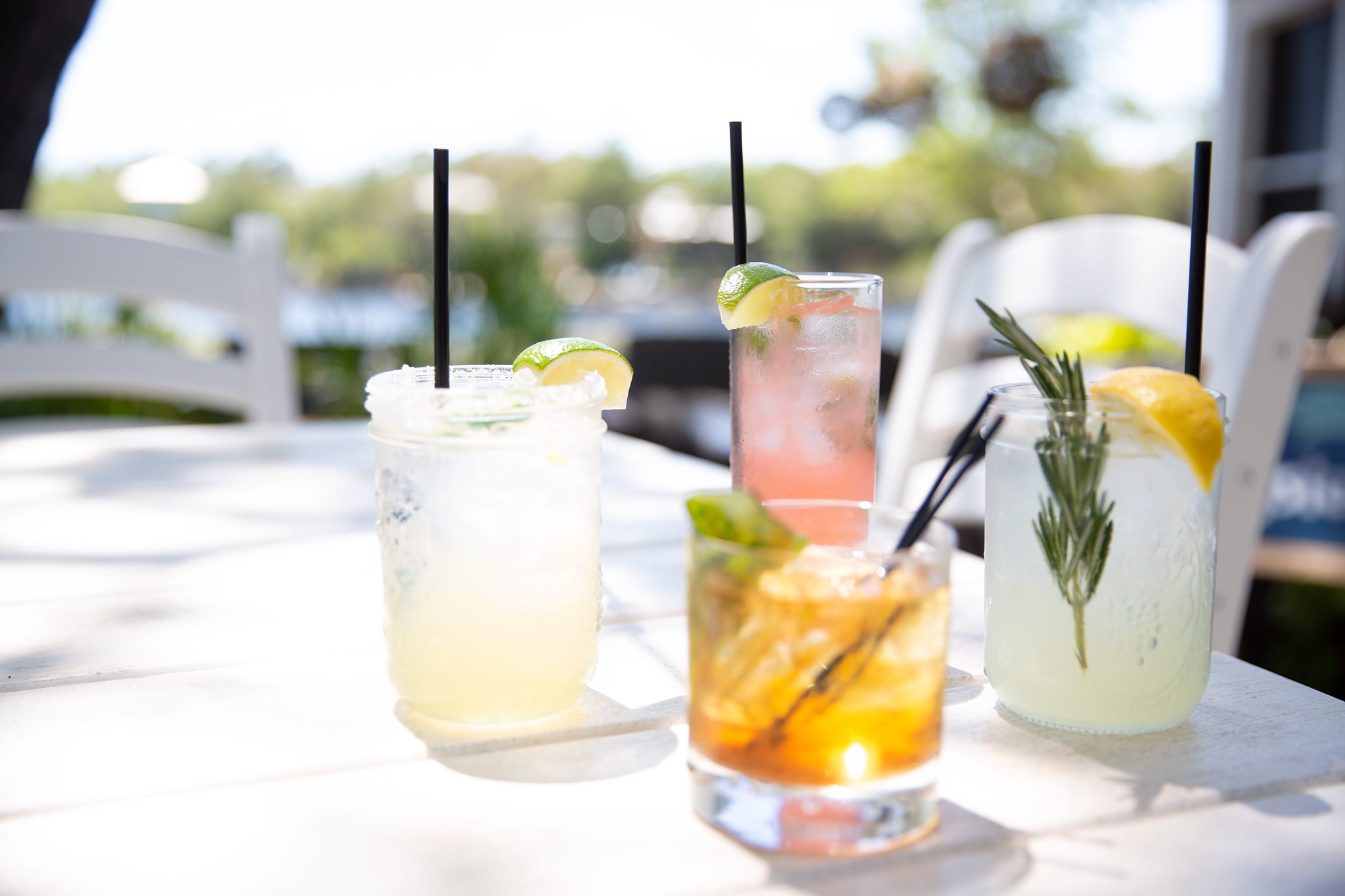 Selection of handcrafted signature cocktails served on the waterfront patio at Old Florida Fish House, including margaritas, citrus cocktails, and an Old Fashioned.