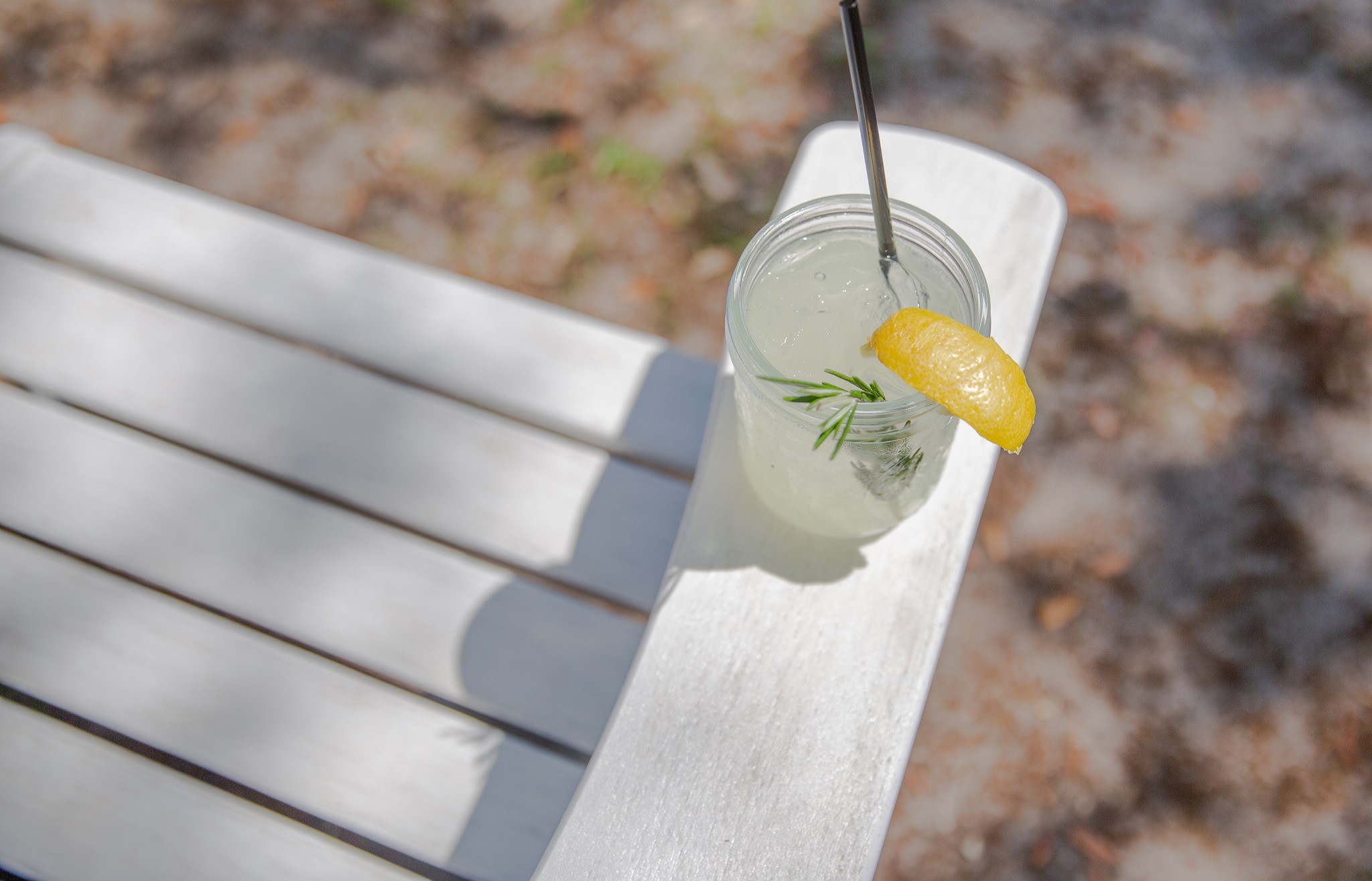 Top view of a handcrafted citrus cocktail with rosemary and lemon garnish served in a mason jar at Old Florida Fish House.