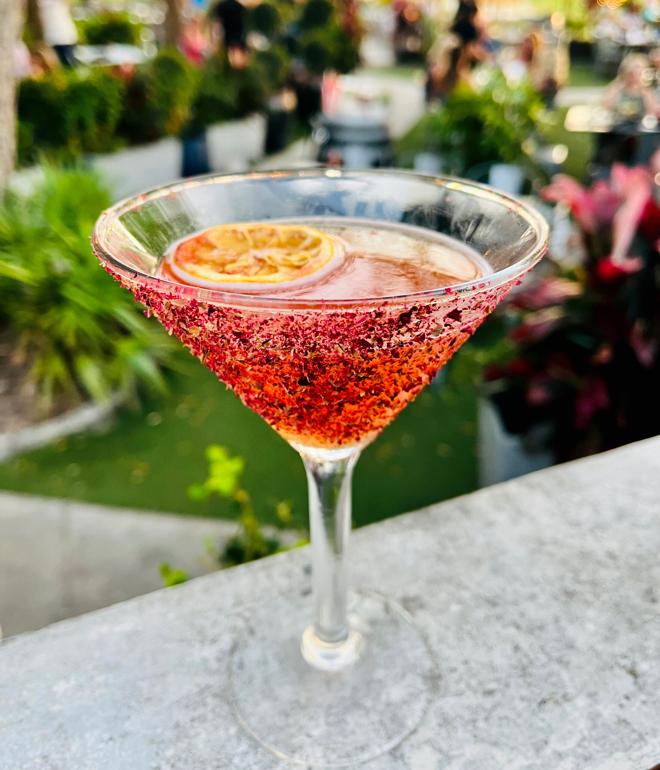 Signature craft cocktail with a floral sugar rim and dehydrated citrus garnish served on the waterfront patio at Old Florida Fish House.