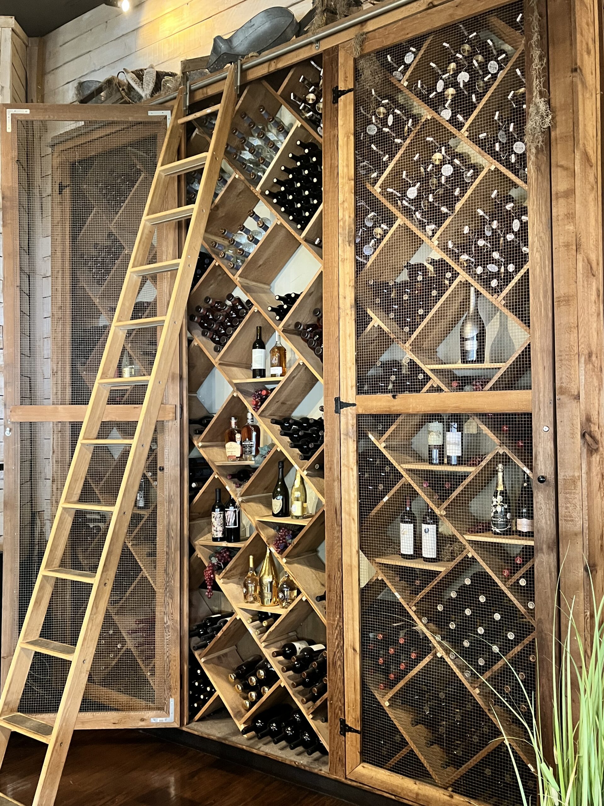 Floor-to-ceiling wine cellar featuring an extensive collection of fine wines, rare bourbons, and champagnes at Old Florida Fish House.