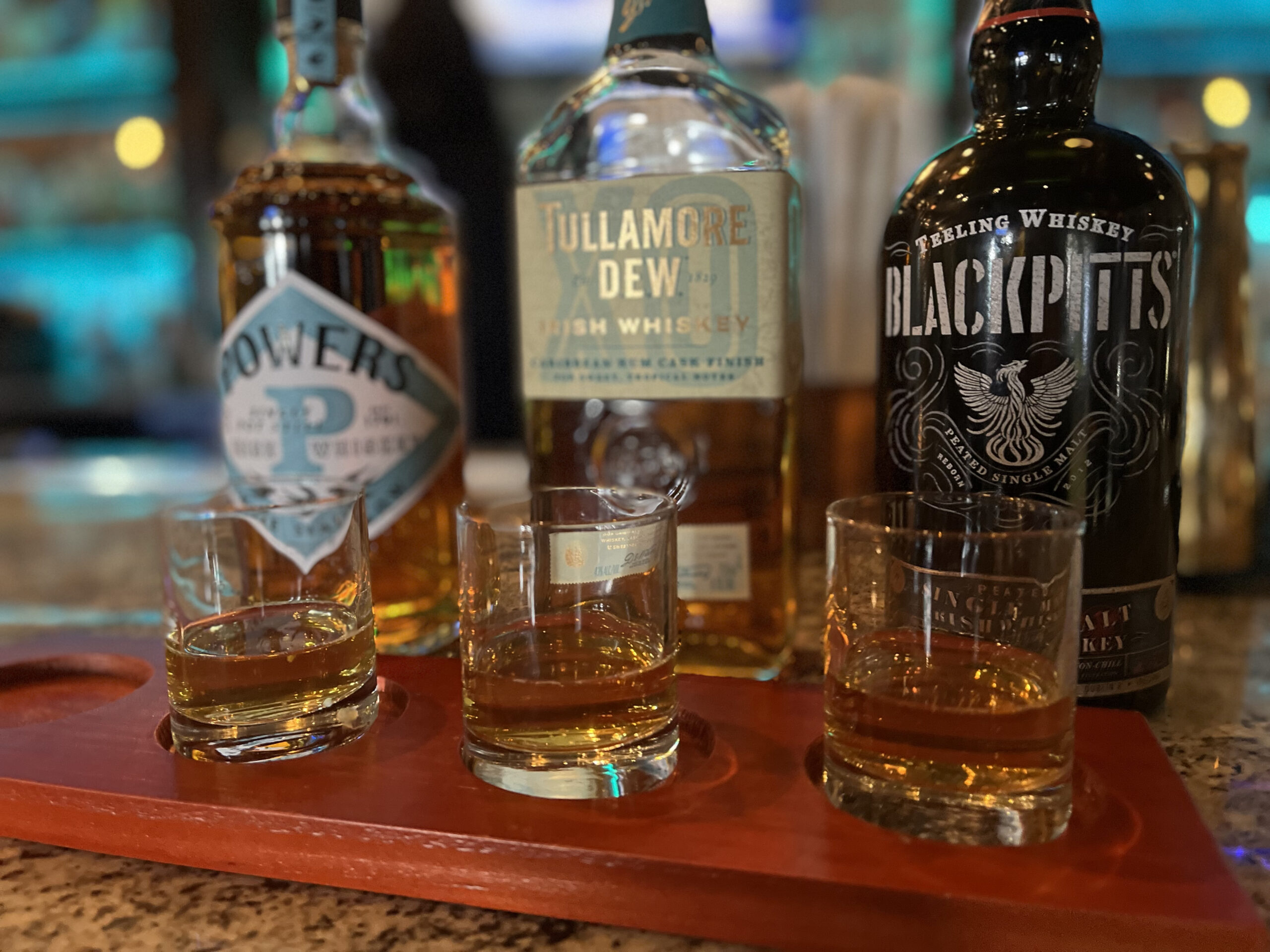 Irish whiskey flight featuring Powers, Tullamore D.E.W., and Teeling Blackpitts served at the bar at Old Florida Fish House.